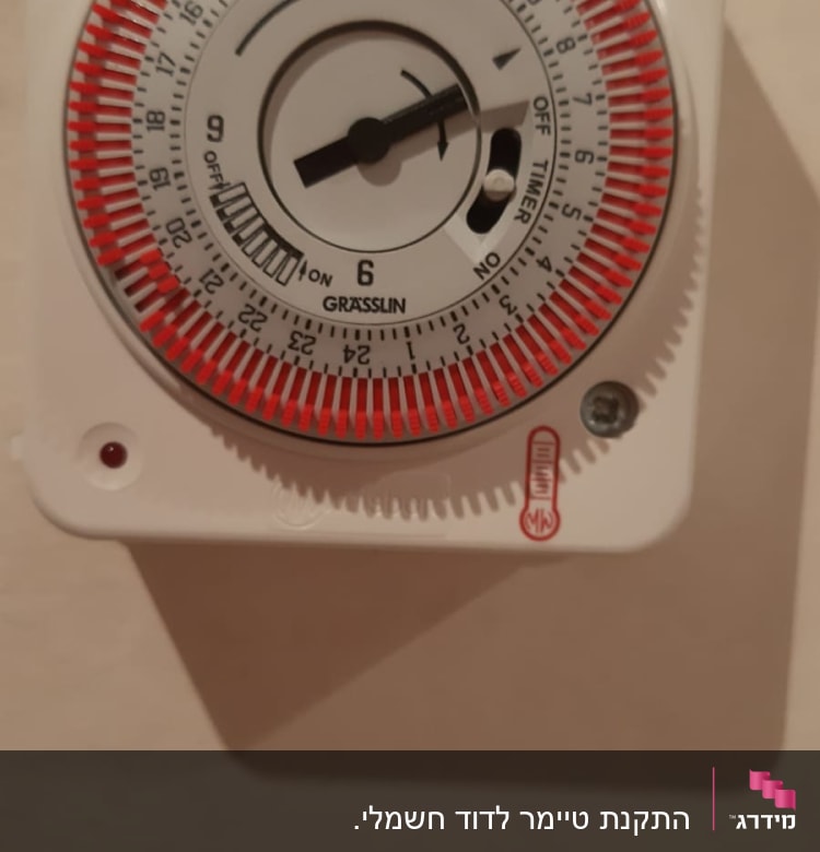 טיימר חשמלי עם מחוגים אדומים ושחור